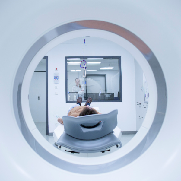 Patientin wird von einer Ärztin in einem MRT-Scanner positioniert.