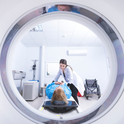 Patientin wird von einer Ärztin in einem MRT-Scanner positioniert.