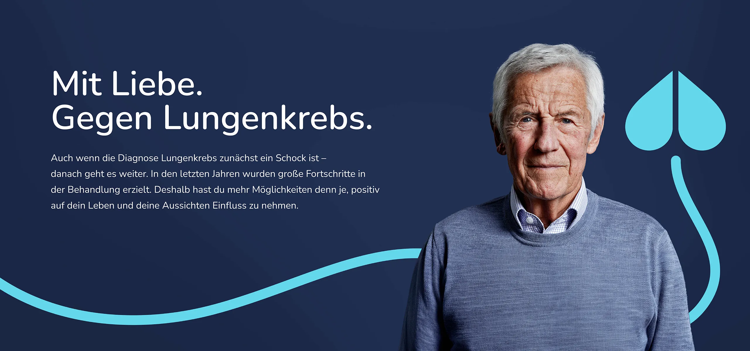 Ein älterer Mann steht neben einer junge Frau vor einem Hintergrund. Beide haben einen blauen Pullover an und blicken ernst nach vorne.