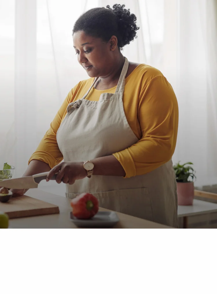 Frau mit Diabetes setzt auf gesunde Ernährung und schneidet Avocado Frau mit Diabetes setzt auf gesunde Ernährung und schneidet Avocado