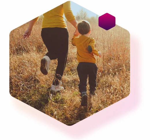 Glücklicher Alltag mit Diabetes: Mutter läuft mit ihrem Sohn über eine Wiese Glücklicher Alltag mit Diabetes: Mutter läuft mit ihrem Sohn über eine Wiese
